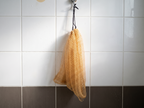 Filet exfoliant KOYIA suspendu dans la douche, en train de sécher